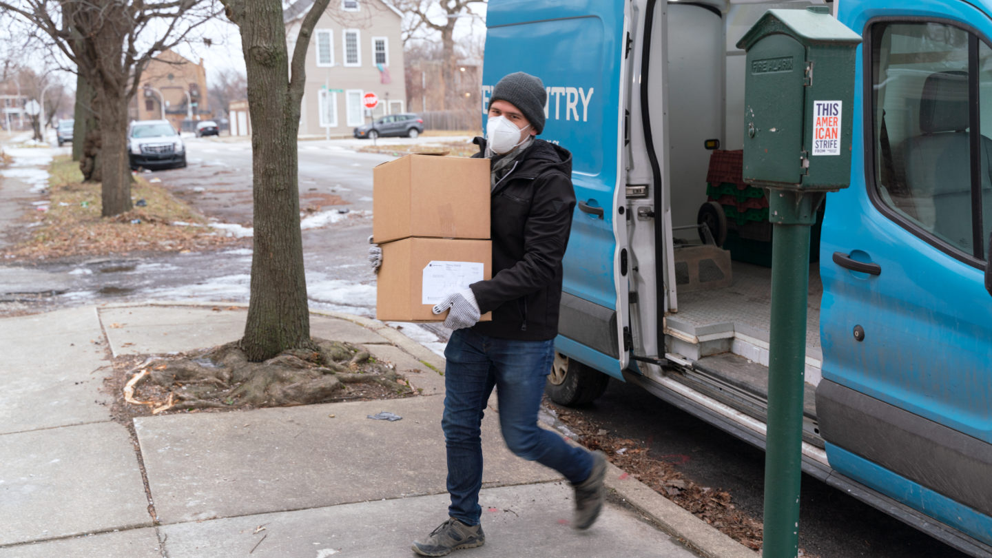 Lance Aguilar, a driver for Nourishing Hope, unloads boxes of groceries at the Primo Center shelter in Englewood. 