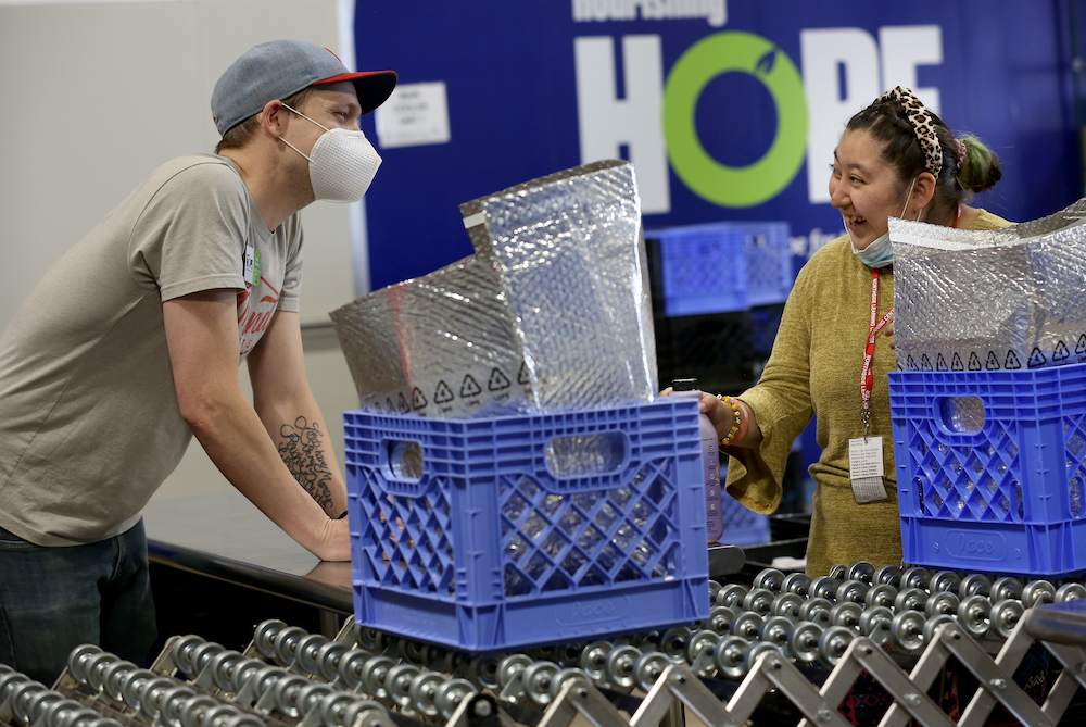 Austin Bloomberg, warehouse superviser at Nourishing Hope, chats with student Daisy Maya.