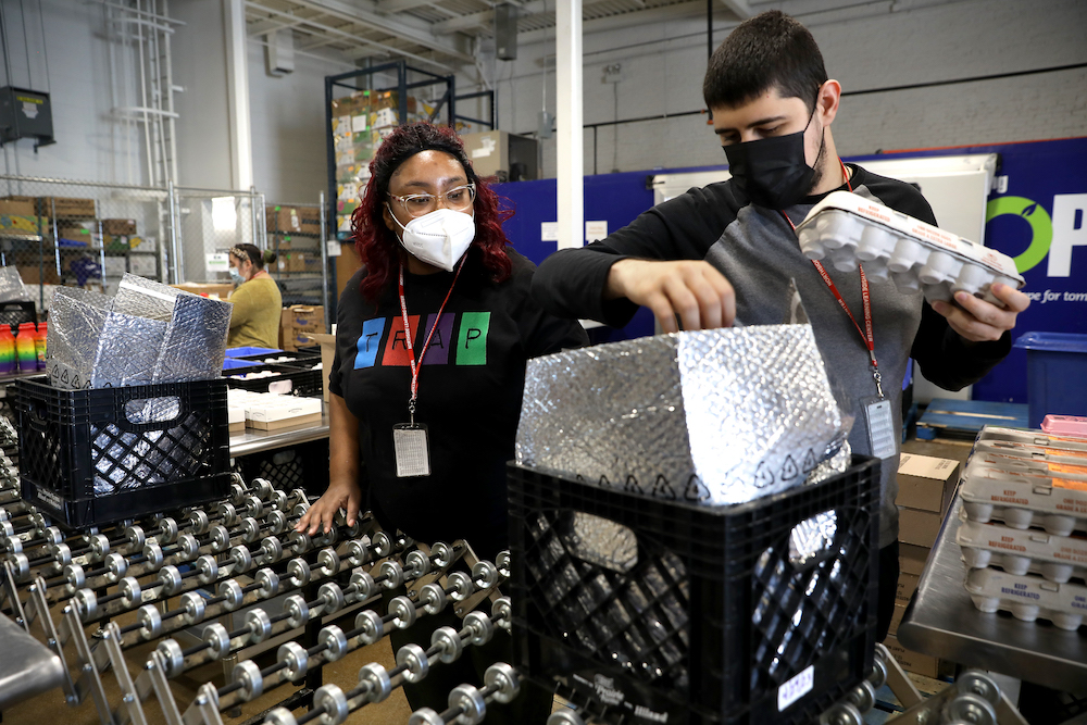 Monique Whitehead and George Tudorache, both students at Northside Learning Center, pack dairy bags at Nourishing Hope.