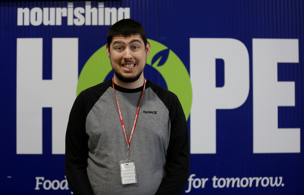 Student George Tudorache poses for a portrait in the Nourishing Hope warehouse. 