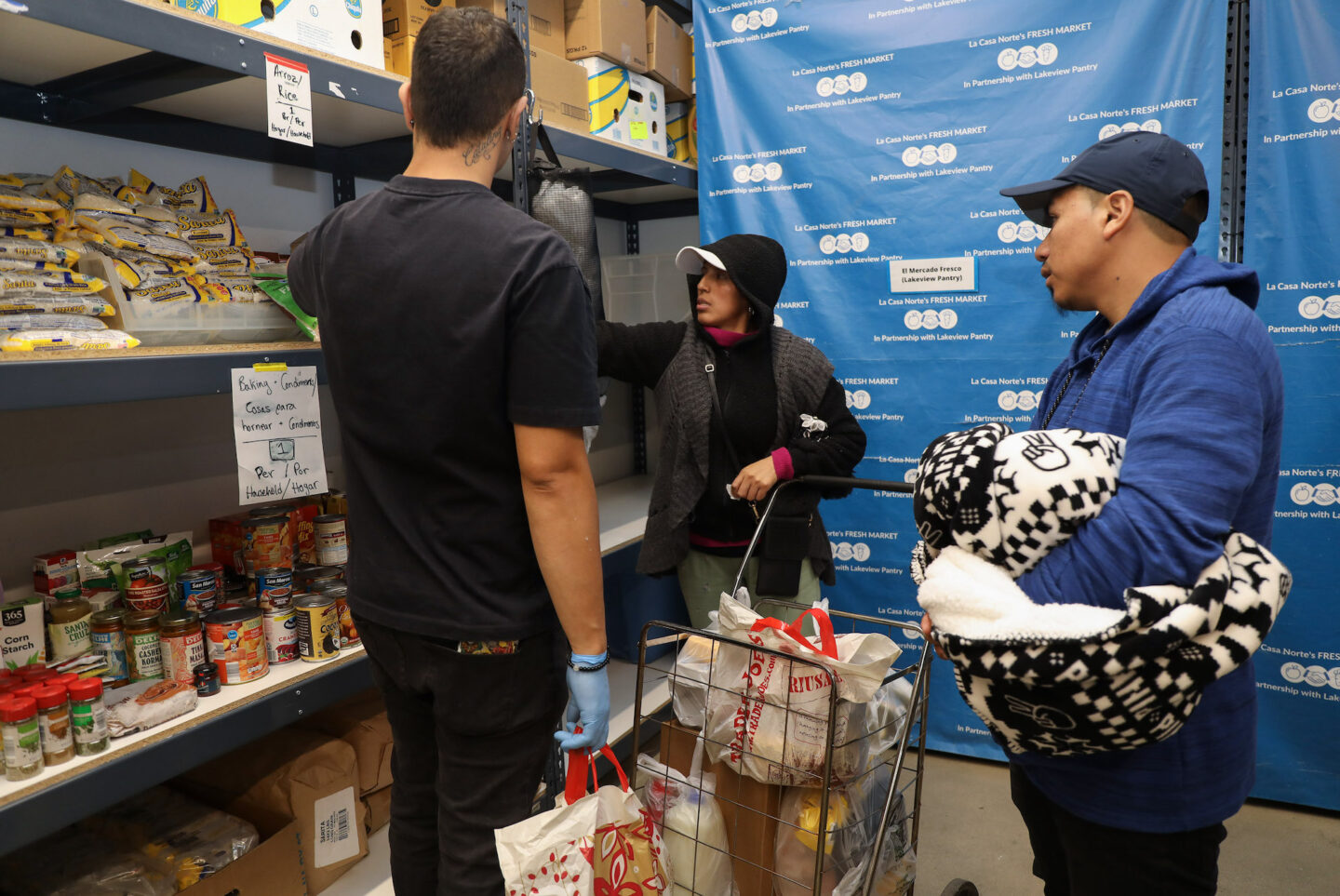 A volunteer, at left, helped Elsa and Cristian select their groceries at El Mercadito. 