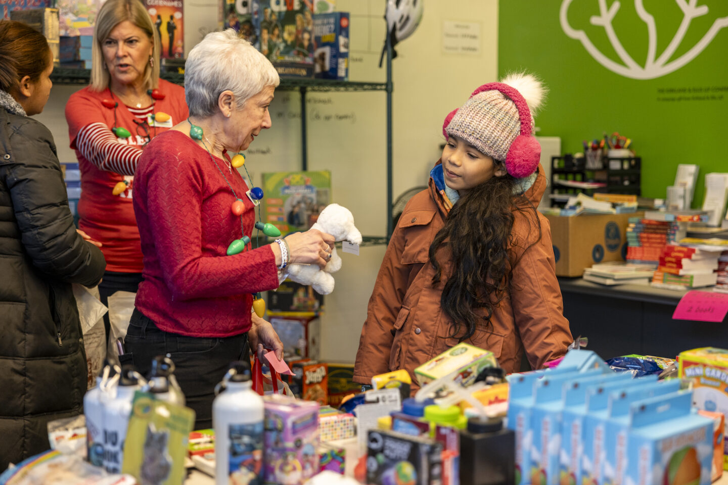 Longtime volunteer Marlene Rotstein talks to a girl during the toy distribution. 