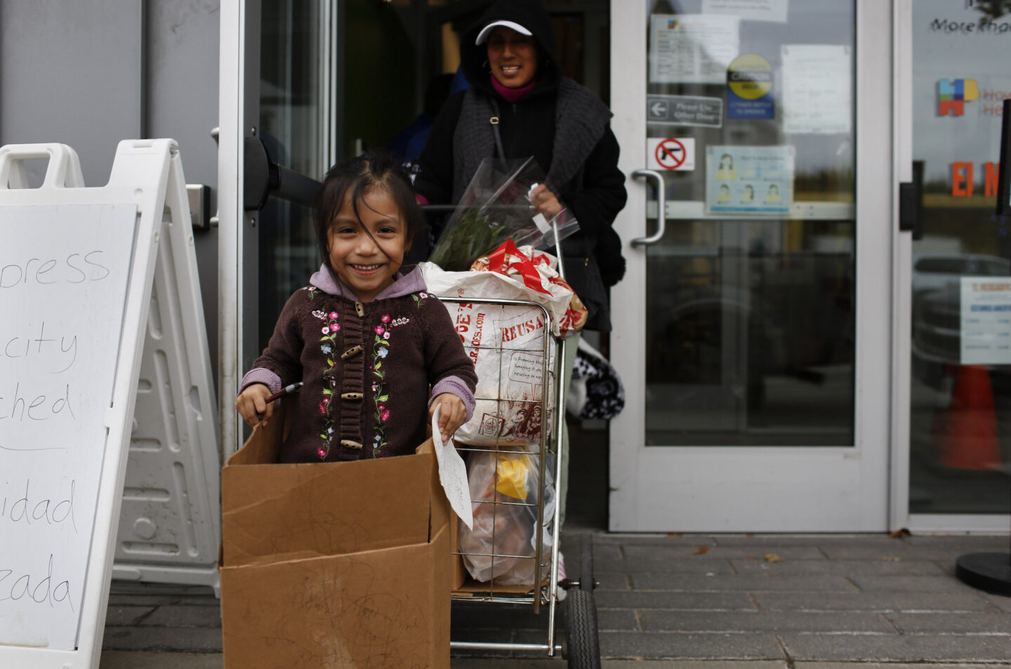 Elsa Chaluisa and her daughter Renata leave El Mercadito with their groceries. 