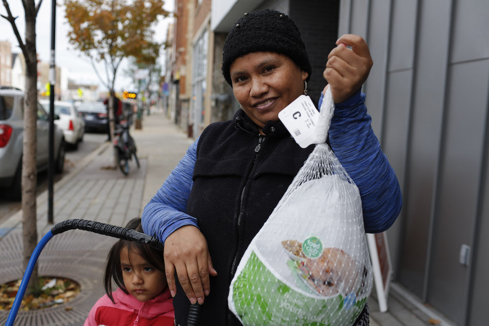 A mother and daughter receive a Thanksgiving turkey at El Mercadito. 